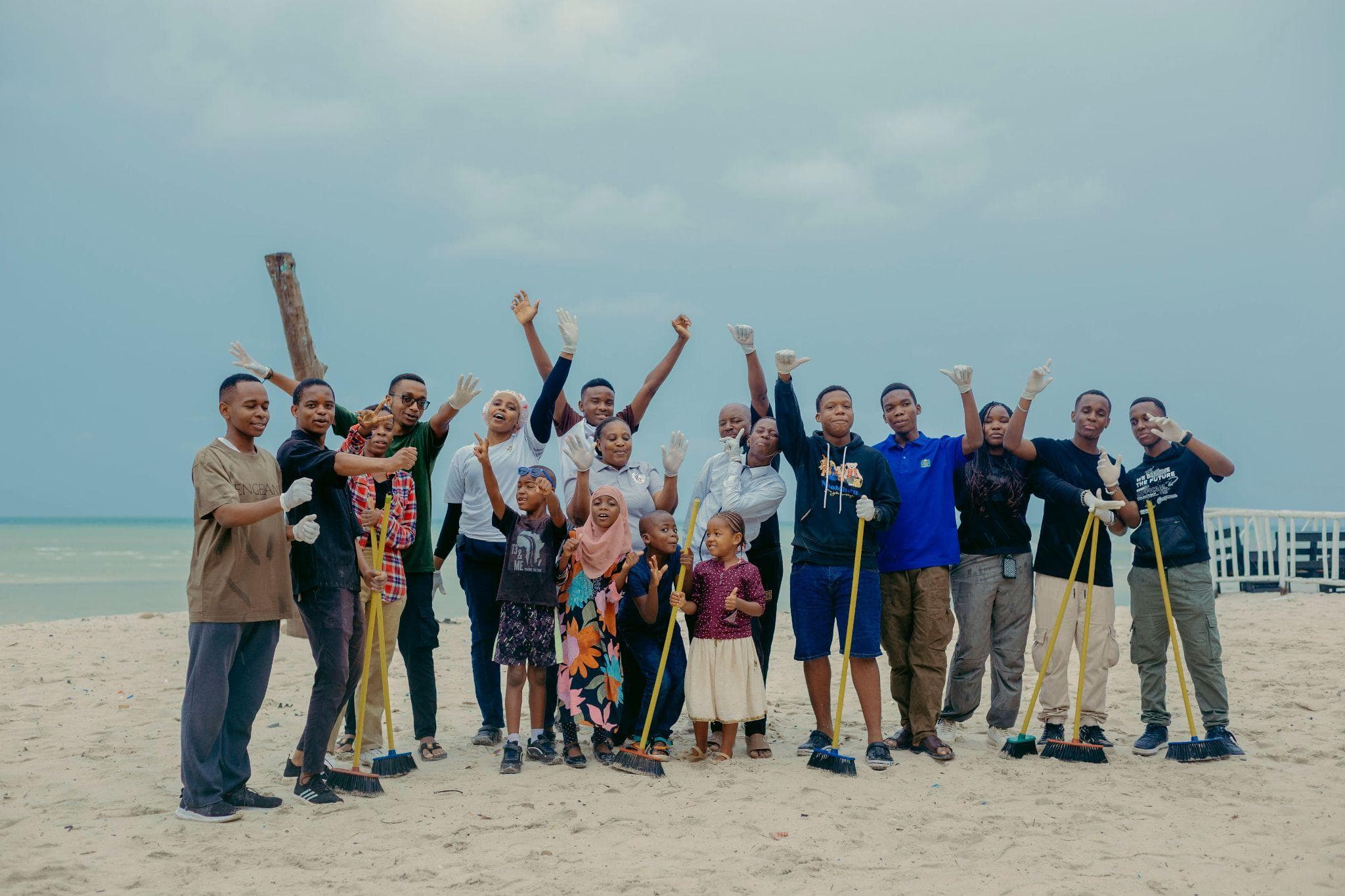 Think Green volunteers and children gathered on a beach in Dar es Salaam